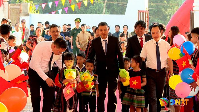 Phó Chủ tịch Thường trực UBND thành phố Hồ Kỳ Minh cùng các đại biểu dẫn học sinh vào dự lễ khai giảng năm học mới. Ảnh: VŨ QUÂN