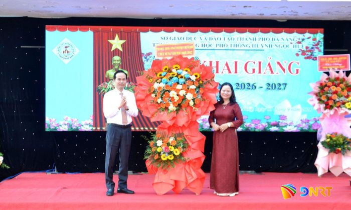 Phó Trưởng đoàn Đại biểu Quốc hội thành phố Nguyễn Duy Minh (bên trái) tặng hoa chúc mừng nhà trường. Ảnh: CÔNG TÚ