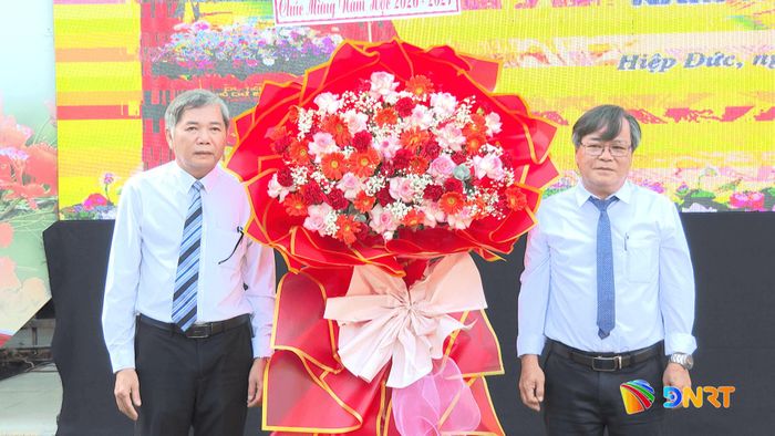 Quyền Giám đốc Báo và phát thanh, truyền hình Đà Nẵng Mai Văn Tư (bên trái) tặng hoa chúc mừng khai giảng tại Trường THPT Hiệp Đức. Ảnh: VĂN HẢI