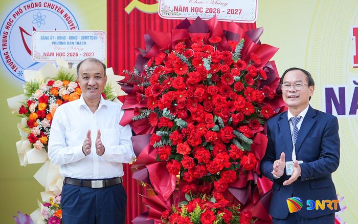 Phó Chủ tịch UBND thành phố Lê Quang Nam (bên trái) tặng hoa chúc mừng khai giảng năm học mới tại Trường THPT chuyên Nguyễn Bỉnh Khiêm. Ảnh: HỒ QUÂN