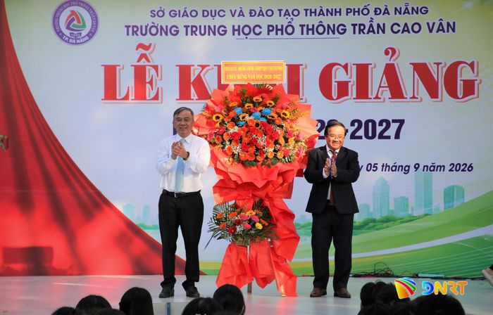 Phó Chủ tịch HĐND thành phố Trần Xuân Vinh (bên trái) tặng hoa chúc mừng thầy và trò Trường THPT Trần Cao Vân nhân dịp khai giảng. Ảnh: ALĂNG NGƯỚC