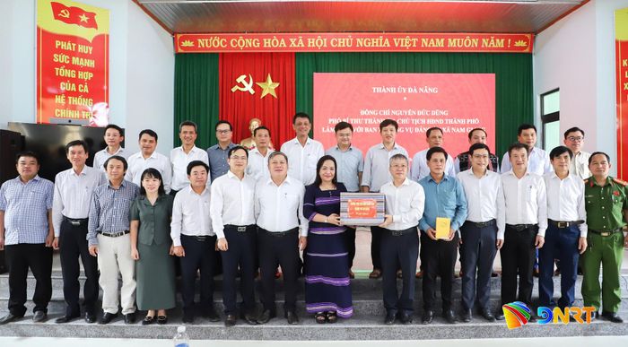 Chủ tịch HĐND thành phố Nguyễn Đức Dũng tặng quà Đảng ủy xã Nam Giang. Ảnh: NGỌC PHÚ