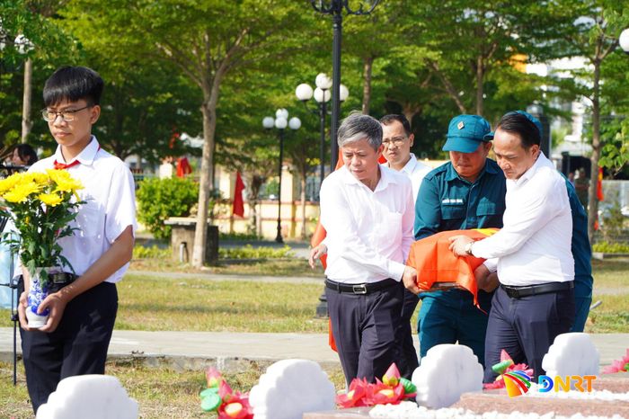 Phó Bí thư Thành ủy, Chủ tịch Ủy ban MTTQ Việt Nam thành phố Nguyễn Đình Vĩnh (ngoài cùng bên phải) cùng lãnh đạo phường Điện Bàn Đông thực hiện di chuyển hài cốt liệt sĩ đến vị trí an táng. Ảnh: VINH ANH