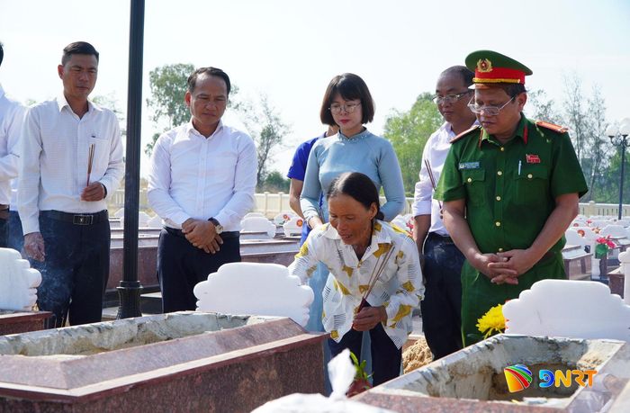 Bà Lê Thị Lạc (người đang thắp hương), đại diện gia đình chăm sóc các phần mộ liệt sĩ đến tham gia lễ truy điệu và an táng hài cốt liệt sĩ. Ảnh: VINH ANH