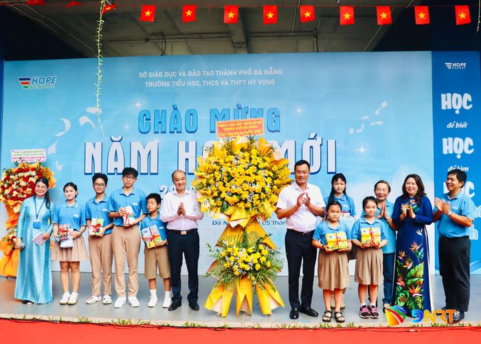 Bí thư Thành ủy Lê Ngọc Quang (áo trắng bên phải) và lãnh đạo thành phố tặng hoa, quà chúc mừng năm học mới cho Trường Hy Vọng. Ảnh: QUỐC TUẤN