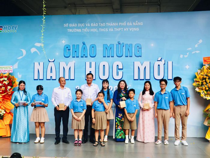 Học sinh Trường Hy Vọng tặng quà lưu niệm cho lãnh đạo thành phố. Ảnh: QUỐC TUẤN