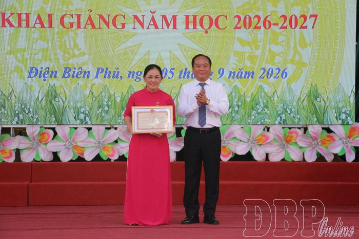 Phó Chủ tịch UBND tỉnh Nguyễn Minh Phú trao Kỷ niệm chương “Vì sự nghiệp xây dựng và phát triển tỉnh Điện Biên” cho cô giáo Nguyễn Thị Tim.