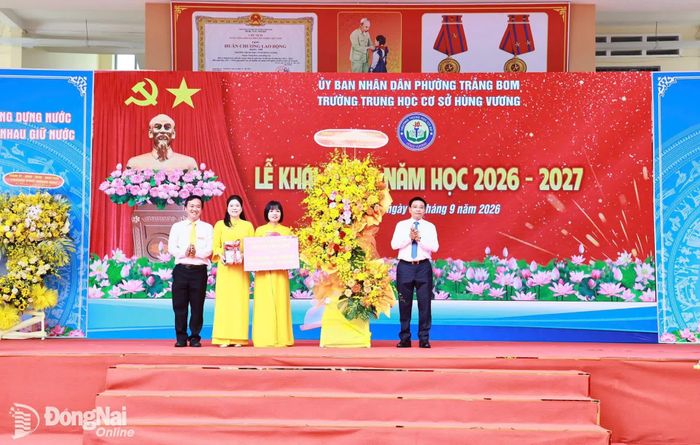 Đồng chí Nguyễn Văn Thắng, Ủy viên Trung ương Đảng, Phó Thủ tướng Chính phủ trao tặng bảng biểu trưng 90 bộ sách giáo khoa THCS và 1.708 bộ sách tham khảo cho thư viện Trường THCS Hùng Vương, phường Trảng Bom. Ảnh: Công Nghĩa