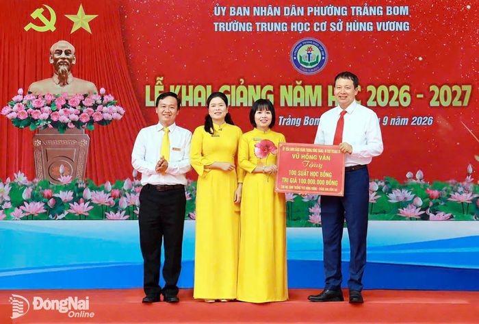 Đồng chí Vũ Hồng Văn, Ủy viên Trung ương Đảng, Bí thư Thành ủy, Trưởng đoàn Đại biểu Quốc hội thành phố Đồng Nai trao tặng 100 phần quà cho các em học sinh hiếu học của Trường THCS Hùng Vương. Ảnh: Công Nghĩa