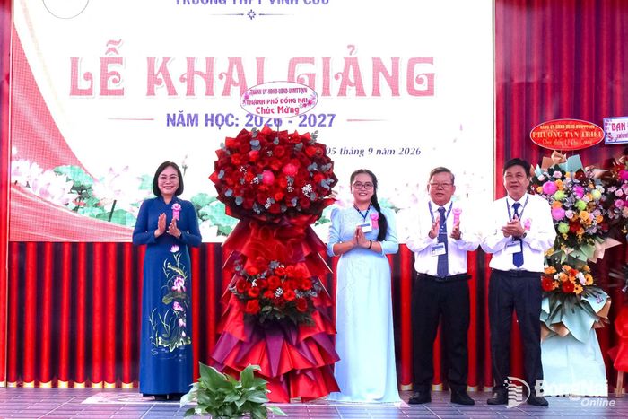 Thành ủy viên, Phó Chủ tịch UBND thành phố Nguyễn Thị Hoàng trao tặng lẵng hoa của Thành ủy, HĐND, UBND, Ủy ban MTTQ Việt Nam thành phố chúc mừng thầy trò Trường THPT Vĩnh Cửu năm học mới. Ảnh: Nguyệt Hà