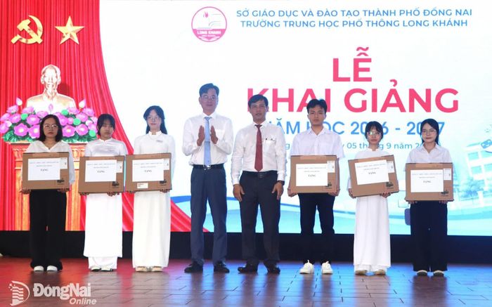 Bí thư Đảng ủy phường Long Khánh Nguyễn Quang Phương tặng hoa và quà tại lễ khai giảng. Ảnh: Ngọc Liên
