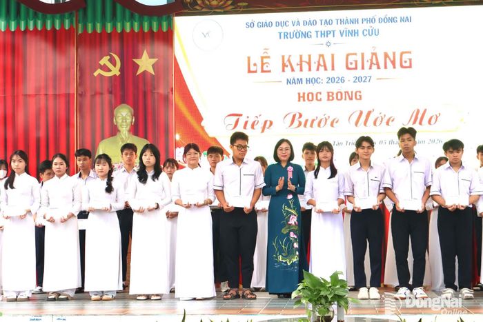 Thành ủy viên, Phó Chủ tịch UBND thành phố Nguyễn Thị Hoàng trao tặng học bổng cho học sinh trong lễ khai giảng. Ảnh: Nguyệt Hà
