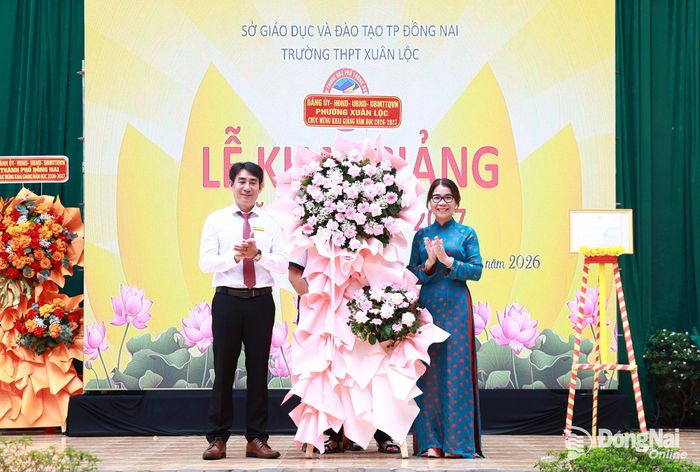 Phó Bí thư Thường trực Đảng ủy phường Xuân Lộc Ngô Thị An tặng lẵng hoa của Đảng ủy, HĐND, UBND, Ủy ban MTTQ Việt Nam phường Xuân Lộc chúc mừng Trường THPT Xuân Lộc đón năm học mới. Ảnh: Ngọc Hoàng