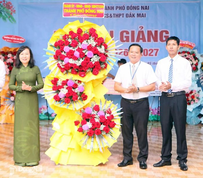 Đồng chí Huỳnh Thị Hằng, Phó Bí thư Thành ủy, Chủ tịch Ủy ban MTTQ Việt Nam thành phố Đồng Nai tặng hoa chúc mừng của Thành ủy - HĐND - UBND - Ủy ban MTTQ Việt Nam thành phố đến thầy và trò Trường THCS-THPT Đắk Mai, xã Bù Gia Mập. Ảnh: Văn Truyên