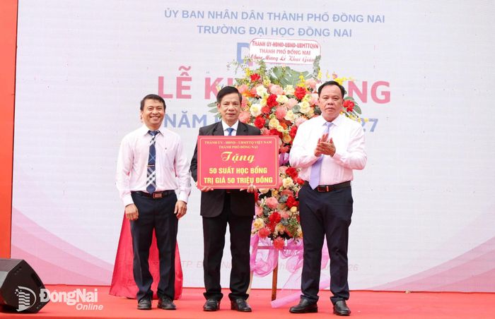 Đồng chí Võ Tấn Đức, Phó Bí thư Thành ủy trao bảng biểu trưng 50 suất học bổng trị giá 50 triệu đồng cho các em học sinh có hoàn cảnh khó khăn của Trường đại học Đồng Nai. Ảnh: Hồ Thảo