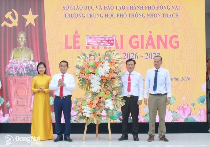 Đồng chí Thái Bảo, Phó Bí thư Thành ủy, Trưởng ban Tổ chức Thành ủy trao lẵng hoa chúc mừng của Thành ủy, HĐND, UBND, Ủy ban MTTQ Việt Nam đến cán bộ, giáo viên, học sinh Trường THPT Nhơn Trạch. Ảnh: N.Hòa