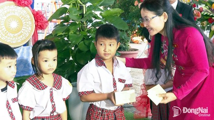Đồng chí Tôn Ngọc Hạnh, Ủy viên Trung ương Đảng, Phó Bí thư Thường trực Thành ủy, Chủ tịch HĐND thành phố tặng quà cho học sinh nhà trường. Ảnh: Nam Hải
