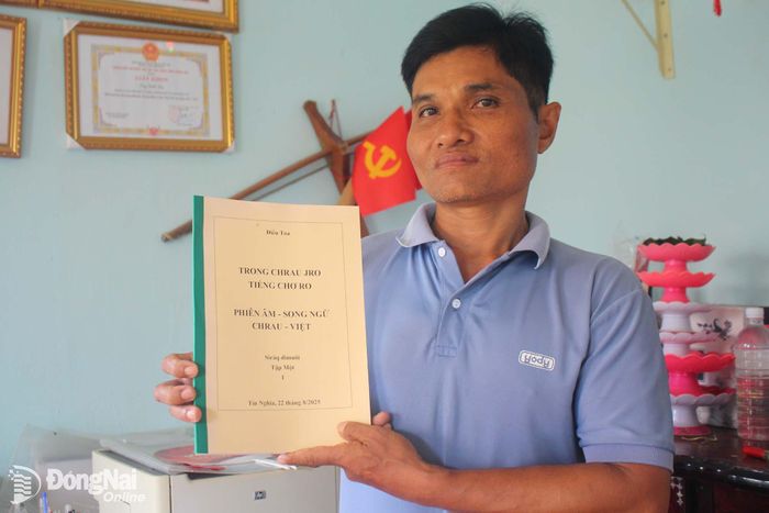 Người có uy tín Điểu Toa (ở khu phố Xuân Thiện, phường Bình Lộc) với tập sách nghiên cứu chữ Chơ-ro của ông.