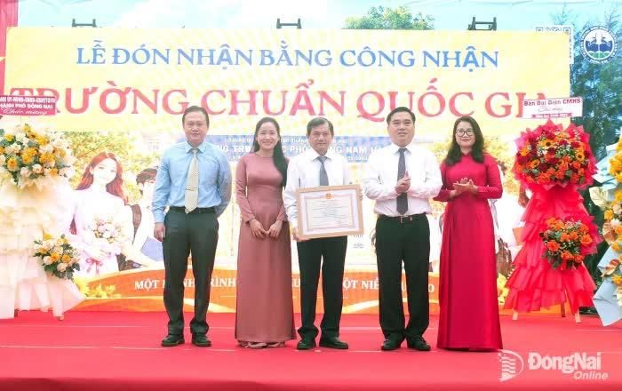 Đồng chí Hồ Văn Nam, Ủy viên Ban Thường vụ Thành ủy, Bí thư Đảng ủy, Chủ tịch HĐND phường Trấn Biên trao Bằng công nhận đạt chuẩn quốc gia cho Ban giám hiệu Trường THPT Nam Hà. Ảnh: Hạnh Dung