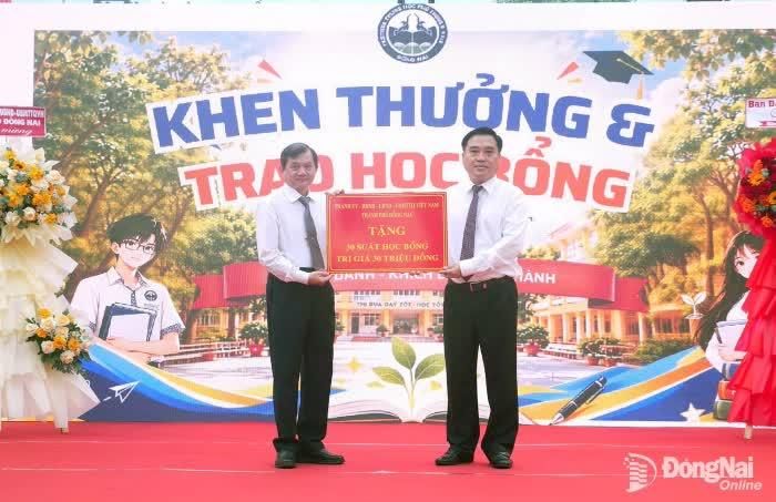 Đồng chí Hồ Văn Nam, Ủy viên Ban Thường vụ Thành ủy, Bí thư Đảng ủy, Chủ tịch HĐND phường Trấn Biên trao học bổng của Thành ủy, HĐND, UBND, Ủy ban MTTQ Việt Nam thành phố Đồng Nai cho các em học sinh Trường THPT Nam Hà. Ảnh: Hạnh Dung
