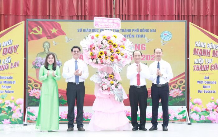 Đồng chí Nguyễn Tuấn Anh, Ủy viên Ban Thường vụ Thành ủy, Phó Chủ tịch UBND thành phố tặng lẵng hoa chúc mừng của Thành ủy, HĐND, UBND, Ủy ban MTTQ Việt Nam thành phố cho nhà trường. Ảnh: Nga Sơn