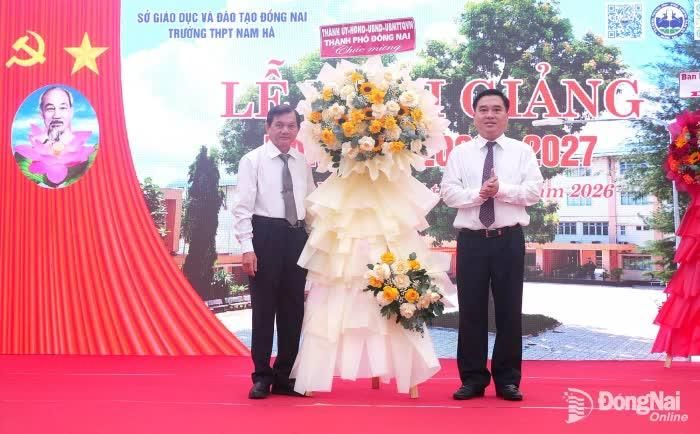 Đồng chí Hồ Văn Nam, Ủy viên Ban Thường vụ Thành ủy, Bí thư Đảng ủy, Chủ tịch HĐND phường Trấn Biên tặng hoa chúc mừng nhà trường. Ảnh: Hạnh Dung