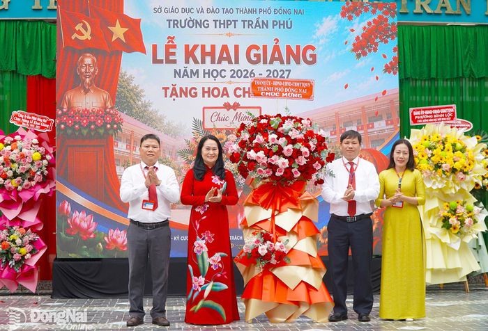 Đồng chí Đặng Minh Nguyệt, Ủy viên Ban Thường vụ Thành ủy, Phó Chủ tịch Thường trực HĐND thành phố Đồng Nai thay mặt Thành ủy, HĐND, UBND, Ủy ban MTTQ Việt Nam thành phố Đồng Nai tặng hoa chúc mừng nhà trường. Ảnh: An Nhơn