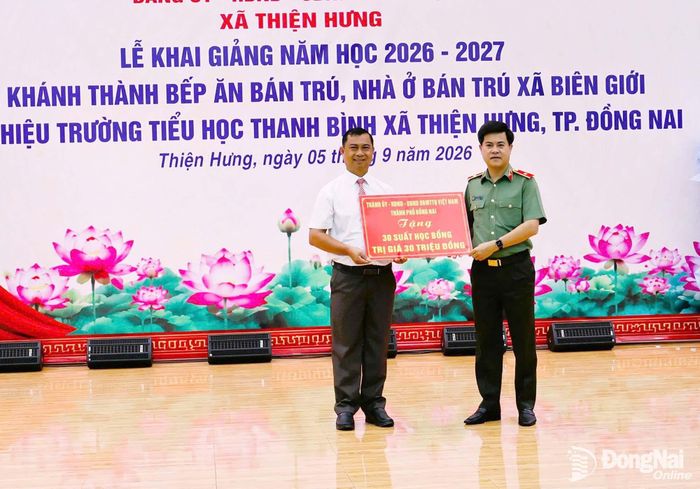 Thiếu tướng Nguyễn Đức Hải, Ủy viên Ban Thường vụ Thành ủy, Giám đốc Công an thành phố Đồng Nai trao bảng biểu trưng học bổng của Thành ủy, HĐND, UBND, Ủy ban MTTQ Việt Nam thành phố Đồng Nai cho đại diện nhà trường. Ảnh: Như Tình