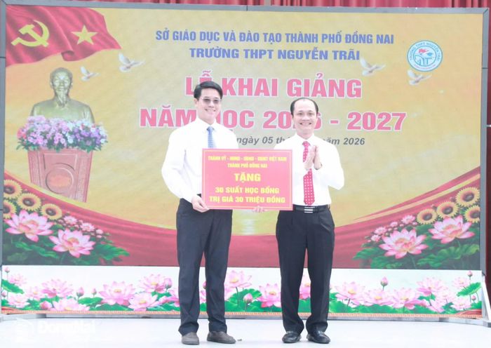 Đồng chí Nguyễn Tuấn Anh, Ủy viên Ban Thường vụ Thành ủy, Phó Chủ tịch UBND thành phố trao bảng biểu trưng 30 suất học bổng của Thành ủy, HĐND, UBND, Ủy ban MTTQ Việt Nam thành phố cho học sinh Trường THPT Nguyễn Trãi. Ảnh: Nga Sơn