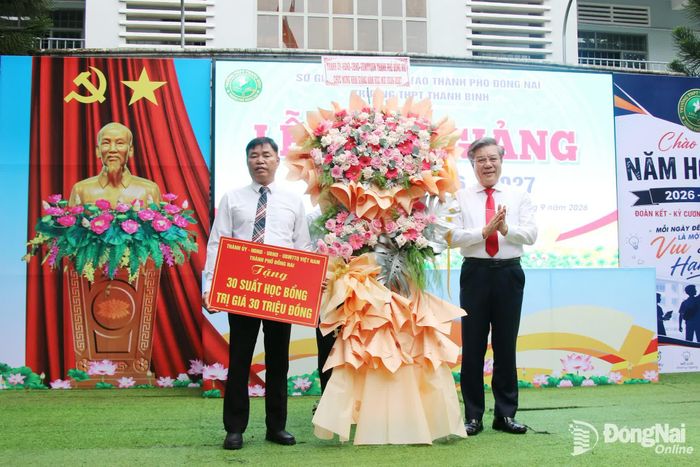 Ủy viên Ban Thường vụ Thành ủy, Trưởng ban Tuyên giáo và Dân vận Thành ủy Dương Minh Dũng tặng lẵng hoa của Thành ủy, HĐND, UBND, Ủy ban MTTQ Việt Nam thành phố chúc mừng nhà trường nhân dịp khai giảng năm học mới. Ảnh: Hải Quân