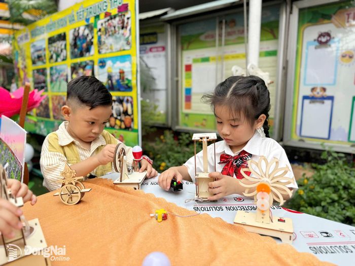 Các em học sinh Trường mầm non Hòa Bình trải nghiệm lắp ráp các mô hình đồ chơi STEM do cô và trò cùng chuẩn bị cho lễ khai giảng năm học mới. Ảnh: Bích Nhàn