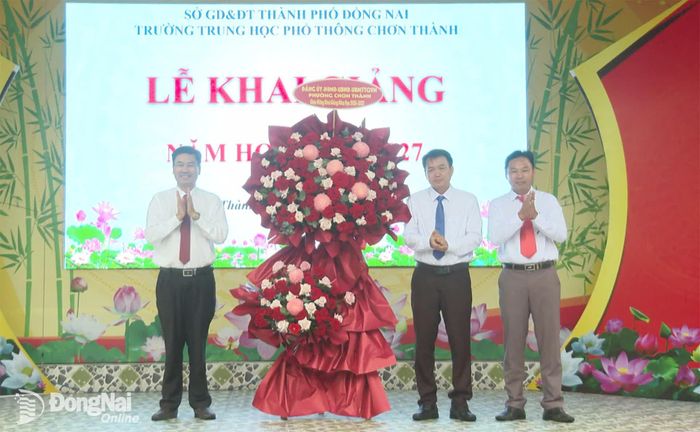 Thành ủy viên, Bí thư Đảng ủy phường Chơn Thành Viên Hồng Tiến tặng hoa chúc mừng Trường THPT Chơn Thành. Ảnh: Đỗ Trình