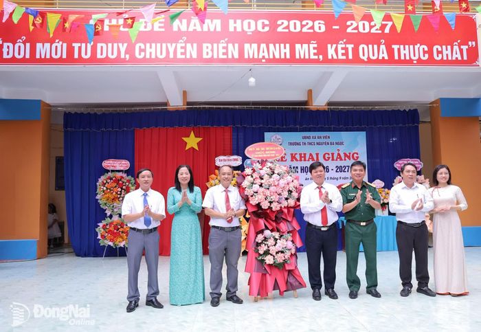 Bí thư Đảng ủy, Chủ tịch HĐND xã Vũ Đình Trung và lãnh đạo xã tặng hoa chúc mừng tập thể Trường TH-THCS Nguyễn Bá Ngọc nhân ngày khai giảng năm học 2026-2027. Ảnh: Thu Bồn