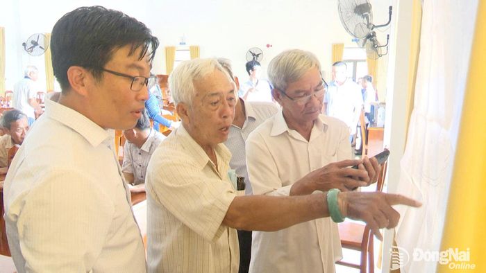  Người dân xã An Phước xem thông tin công khai dự án đại lộ Nguyễn Hữu Cảnh qua địa bàn. Ảnh: CTV