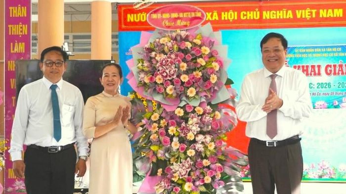 Đồng chí Phạm Thành Ngại trao lẵng hoa chúc mừng năm học mới đến thầy và trò Trường Tiểu học và THCS Tân Hộ Cơ.
