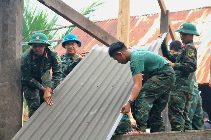  Cán bộ, chiến sĩ Bộ Chỉ huy Quân sự tỉnh Gia Lai hỗ trợ người dân buôn Jứ di dời nhà. Ảnh: Hoàng Hoài 