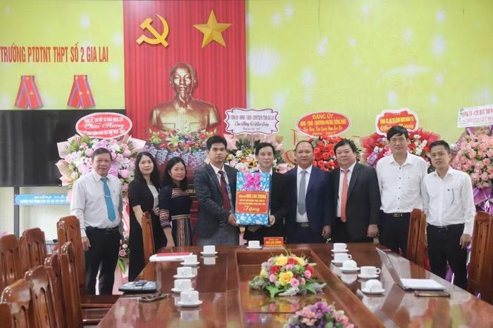Phó Bí thư Thường trực Tỉnh ủy Rah Lan Chung (thứ 4 từ phải sang) tặng quà cho nhà trường. Ảnh: Ngọc Sang