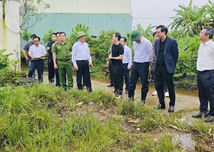  Chủ tịch UBND phường Thống Nhất Phạm Thế Tâm (đứng thứ 4 từ phải sang) báo cáo tình hình ngập tại hẻm 433 Lý Thái Tổ. Ảnh: P.D 