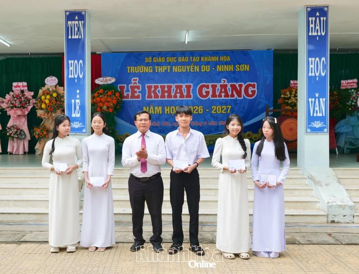 Đại diện nhà trường trao học bổng cho các học sinh vượt khó, vươn lên trong học tập.