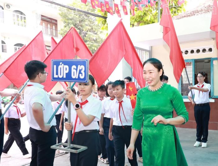 Giáo viên dẫn học sinh lớp 6 vào trường dự lễ khai giảng.