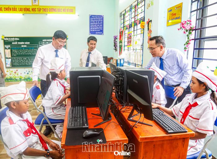 Lãnh đạo các đơn vị và các em học sinh trải nghiệm tại "Góc thư viện số".
