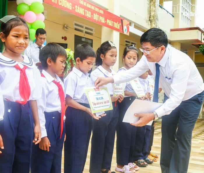 Ông Lê Hoàng Triều - Giám đốc Báo và Phát thanh, Truyền hình Khánh Hòa trao học bổng cho các em học sinh.