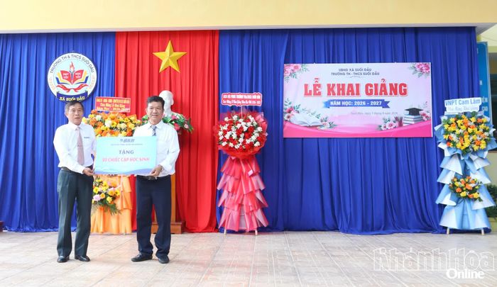 Ông Võ Thanh Lâm trao bảng tượng trưng 50 chiếc cặp cho học sinh có hoàn cảnh khó khăn của nhà trường.