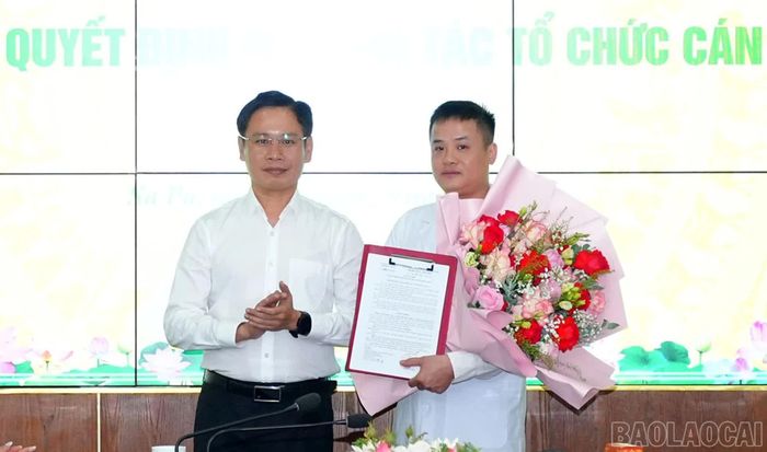 Đồng chí Cao Bá Quý - Chủ tịch UBND phường trao quyết định và tặng hoa chúc mừng tân Phó Giám đốc Trạm Y tế Sa Pa.
