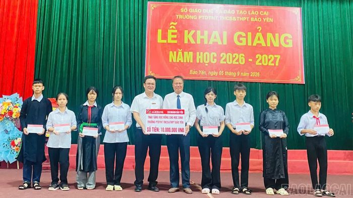 Đại diện Ngân hàng Nông nghiệp và PTNT Chi nhánh Bảo Yên trao học bổng cho các em học sinh.