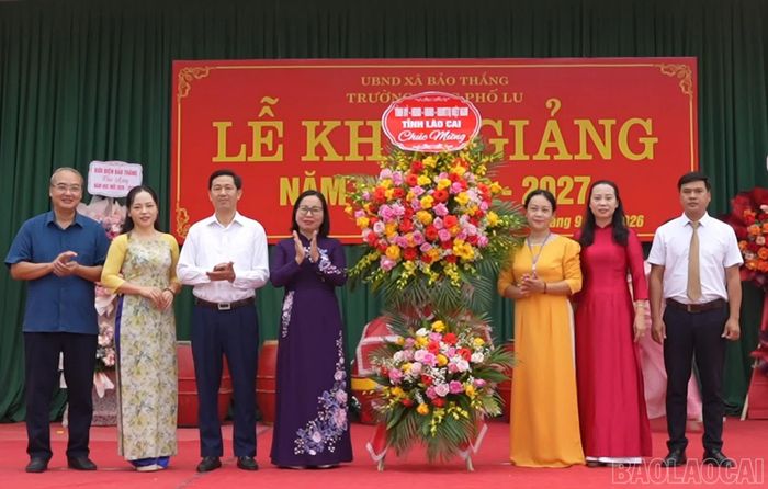  Đồng chí Lý Thị Vinh - Ủy viên Ban Thường vụ Tỉnh ủy, Bí thư Đảng ủy, Chủ tịch HĐND xã Bảo Thắng tặng hoa chúc mừng thầy và trò Trường THCS Phố Lu. 