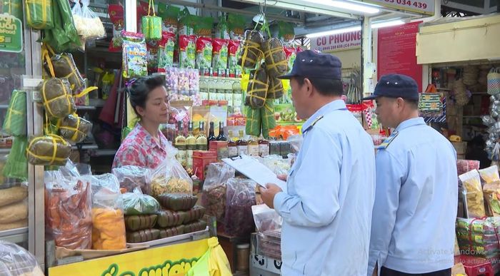 Kiểm tra việc niêm yết giá của tiểu thương. Ảnh: Văn Chinh