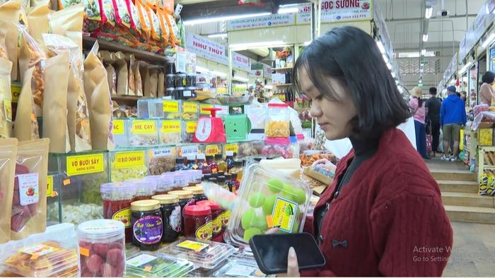 Chị Nguyễn Thị Hoàng An đang chọn mua hàng ở chợ Đà Lạt. Ảnh: Văn Chinh