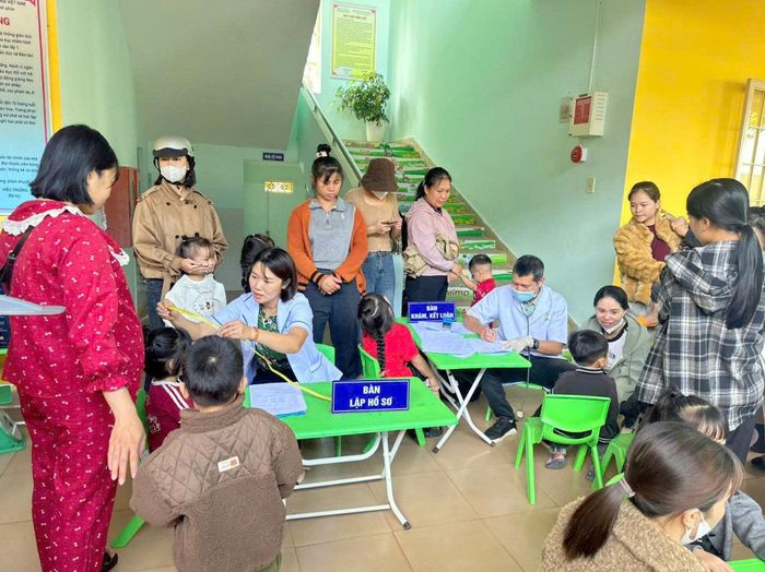 Phụ huynh đưa trẻ đến khám sức khỏe định kỳ tại Trạm y tế xã Nam Ban Lâm Hà.