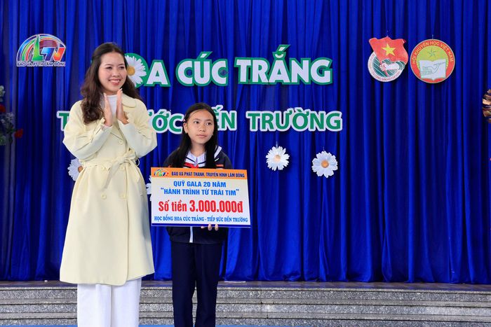 Nhà báo Vân Hảo, Phó Trưởng phòng Chuyên đề trao học bổng từ Quỹ Gala 20 năm “Hành trình từ trái tim” của Báo và Phát thanh, Truyền hình Lâm Đồng cho em Thiên Kim.